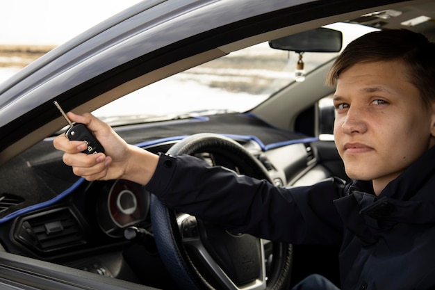 Closeup Young handsome man looks out of a white car