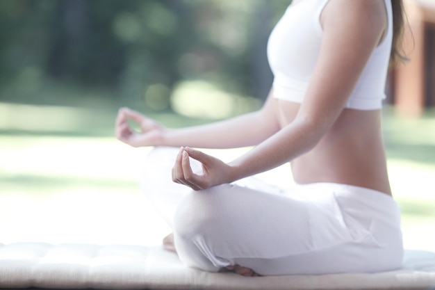 Closeup of young woman doing yoga exercise in the park