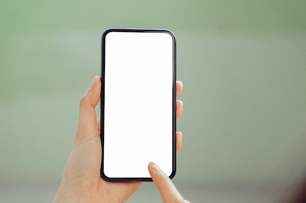 Closeup of young woman hand holding smartphone on the table and the screen is blank	