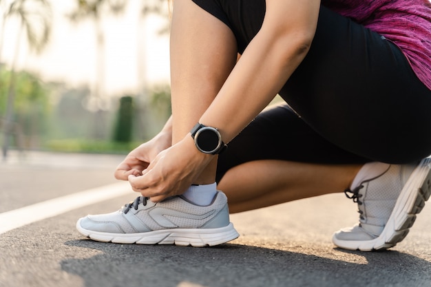 Closeup of young woman runner tying her shoelaces. healthy and fitness concept.