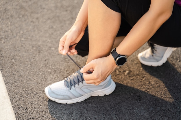 Closeup of young woman runner tying her shoelaces. healthy and fitness concept.