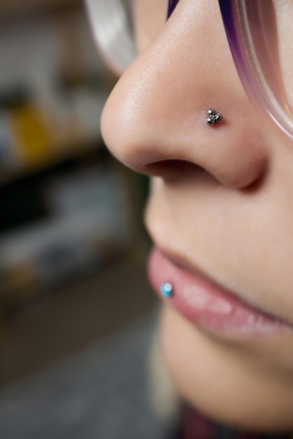 Closeup of a young womans visage with piercing septum hanging from her nose