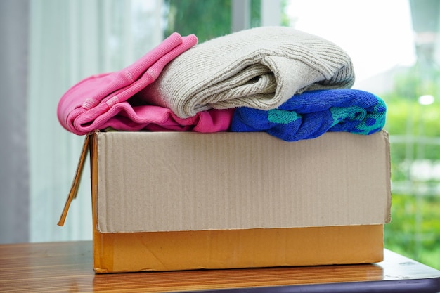 Clothes donations in cardboard box for volunteer