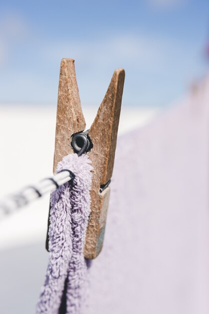 Clothes drying outdoors. Close-up wooden clothespin. Clothes hanging rope.