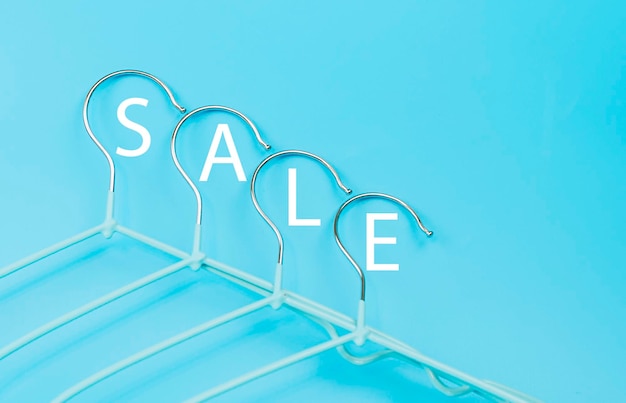 Clothes hangers on a blue background with Tex sale