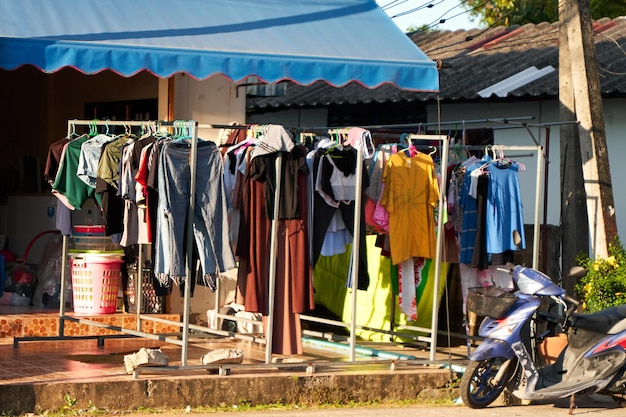 Clothes hangers second hand on the street in front of the house Sale of used clothing