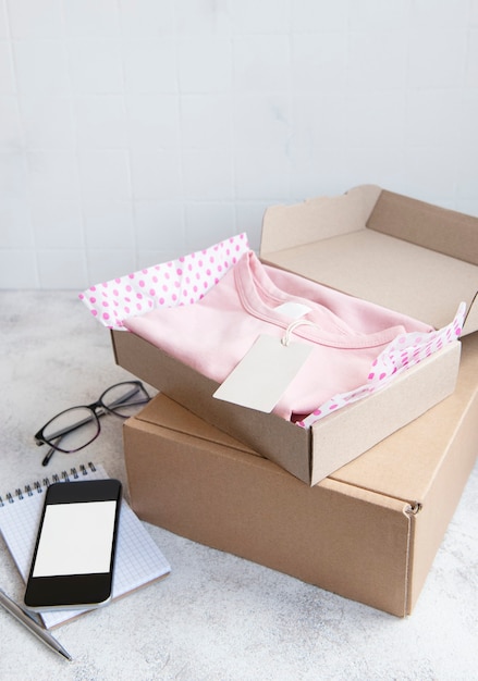 Clothes for kids in an open cardboard box. Online shopping concept. Delivery of clothes.