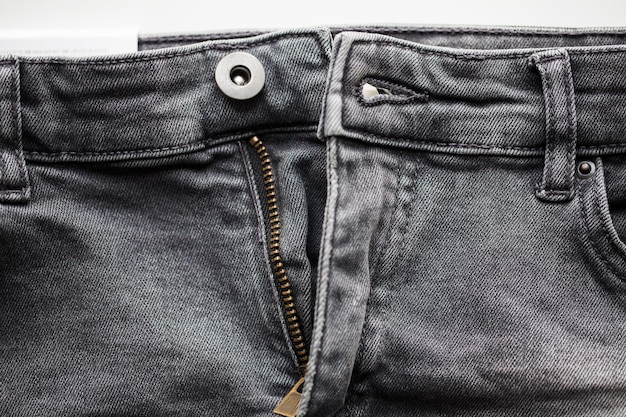 clothes, wear and fashion concept - close up of denim pants or jeans with unfastened zipper