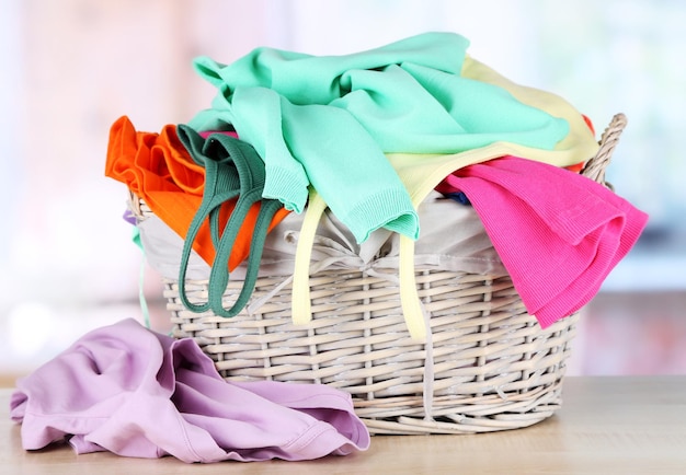 Clothes in wooden basket on table in room