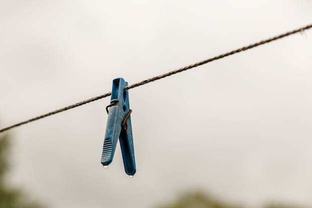 Clothespin hanging from a rope a clothespin hangs from the clothesline blurred background