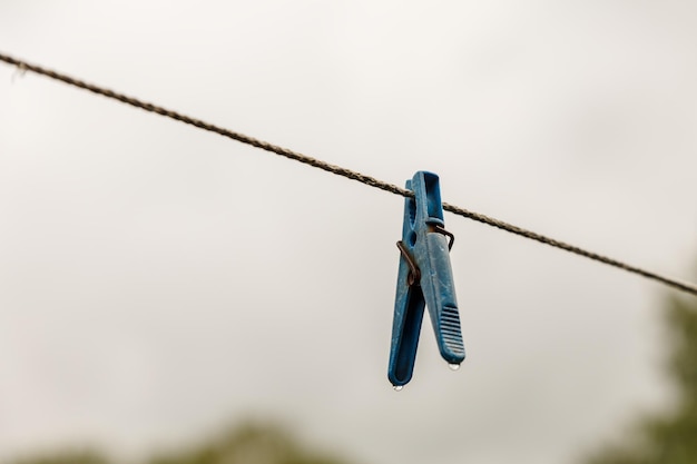 Clothespin hanging from a rope. A clothespin hangs from the clothesline.