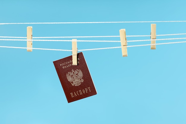 Clothespin on rope holds Russian passport concept dry reputation expectation