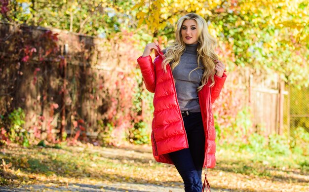 Clothing for autumn walk Must have fall wardrobe Be bright this autumn Autumn season fashion Woman wear coat or warm jacket while stand in park yellow foliage background Girl enjoy autumn walk