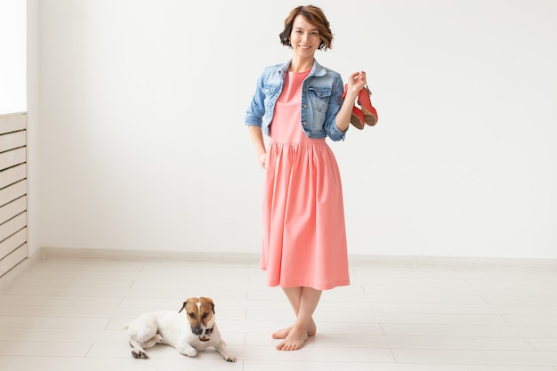 clothing designer, people, pet concept - young woman in dress and jeans jacket with jack russell