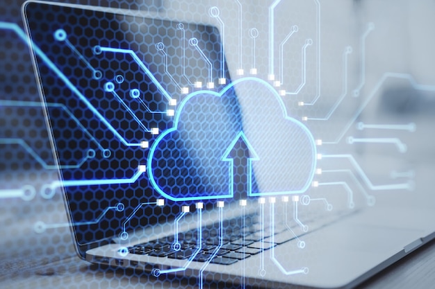 Cloud and internet information storage concept with digital cloud icon with arrow up with microcircuit lines on laptop background