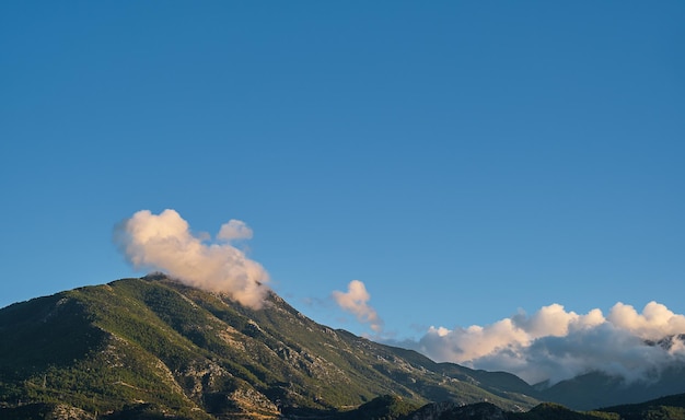 Cloud on a mountain range in the rays of the sun at sunset idea for a background or screensaver natural landscape of the Aegean coast