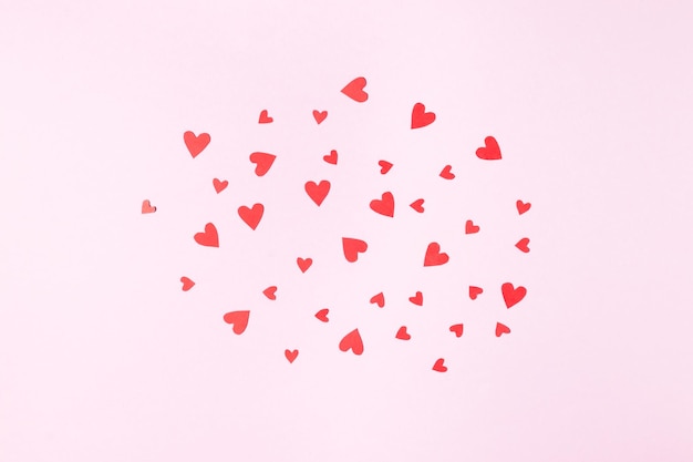 Cloud of red hearts for valentine's day greeting card on pink background