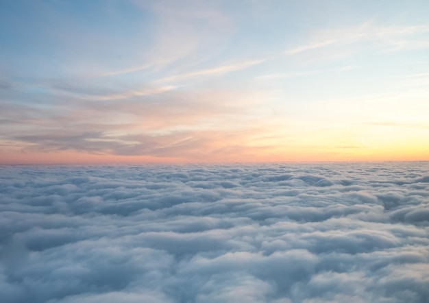 Over clouds from aircraft window view under natural twilight light