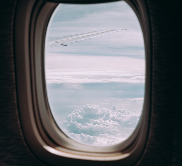 Clouds and sky through window of an aircraft.