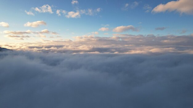 Clouds at sunset are like big ocean waves crashing against high mountains covered with snow.