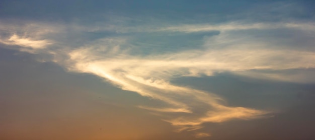 Clouds that are shaped like dragons flying in the sky or S form at sunset background