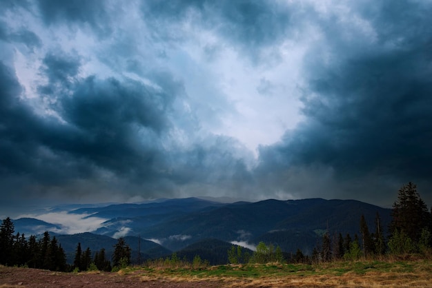 Cloudy weather over hills covered with spruce forests in Rhodope Mountains and fog between mountain ranges