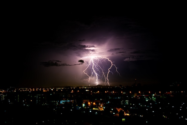 Cloudy with Bright lightning bolt strikes in the rural landscape of small city