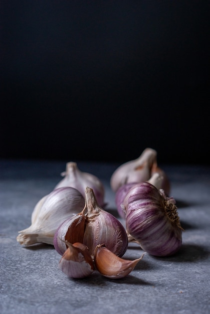 Cloves and bulb of organic natural garlic on dark backround