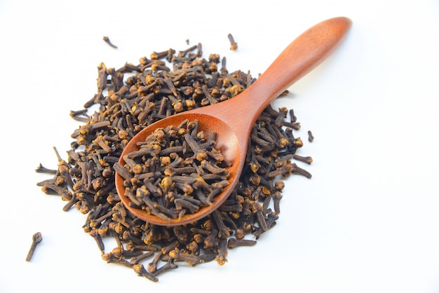 Cloves (spice) and wooden spoon on White background