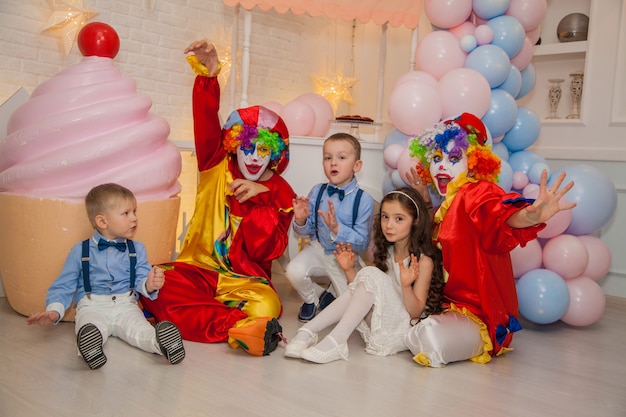 Clown boy and clown girl at childrens party play with children