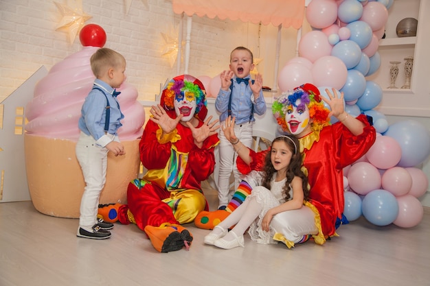 Clown boy with clown girl having fun on a holiday with children