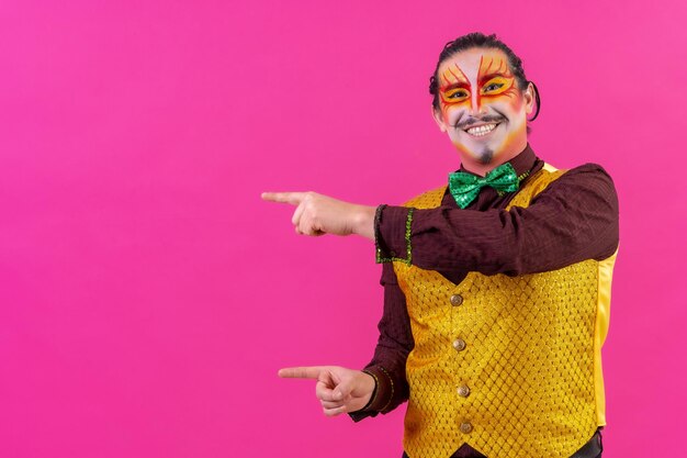 Clown with white facial makeup showing an empty space from the pink background announcing something