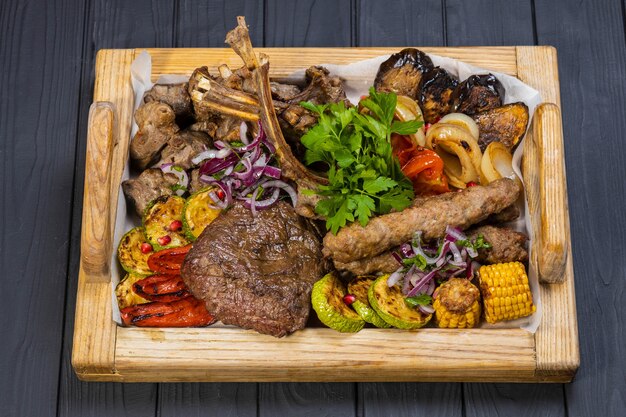 Club Beef steak and Grilled vegetables on board on black wooden