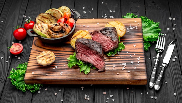 Club Beef steak with pepper sauce and Grilled vegetables on cutting board