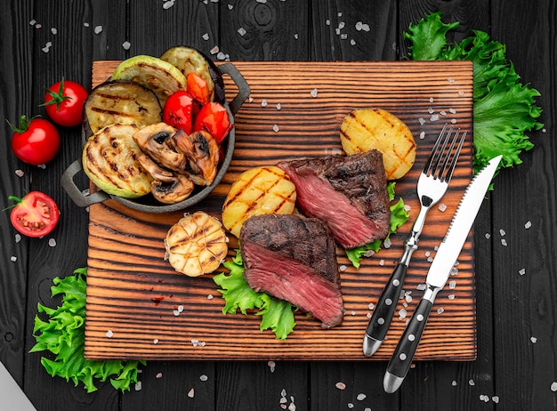 Club Beef steak with pepper sauce and Grilled vegetables on cutting board