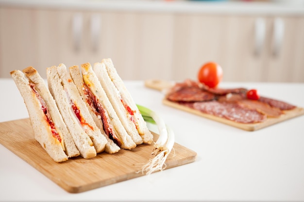 Club sandwiches on a wooden board in the kitchen