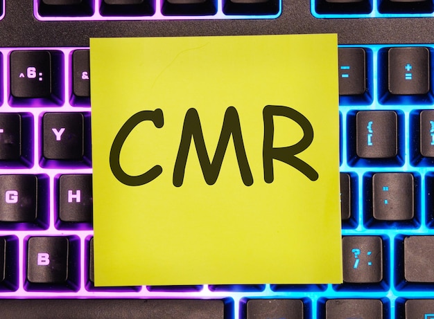 CMR CMR Contract Management Review or Clear Motion Rate written on a yellow sticker on a laptop keyboard with backlight