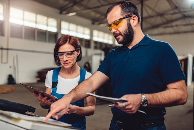 CNC Machine Operator and industrial engineer checking product drawing