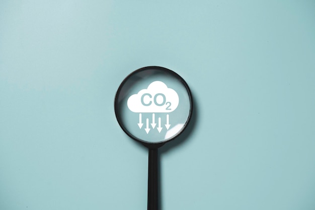 Photo co2 reducing icon inside magnifier glass for focusing decrease co2 or carbon dioxide emission carbon footprint and carbon credit to limit global warming from climate change concept