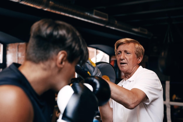 Photo coach teaching boxing to student