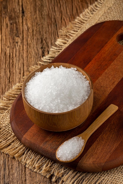 Coarse salt in bowl on wooden background