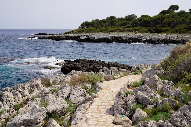 Coast pathway stones on bright summer day view mediterranean sea in south Antibes JuanlesPins France southeast