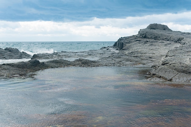 Coastal cliffs formed by columnar basalt at low tide