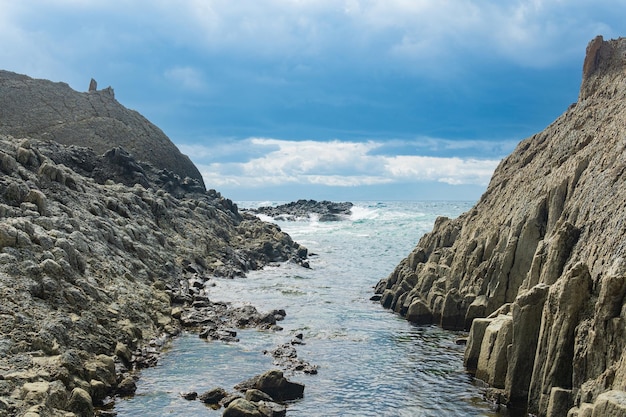 Coastal cliffs formed by columnar basalt at low tide