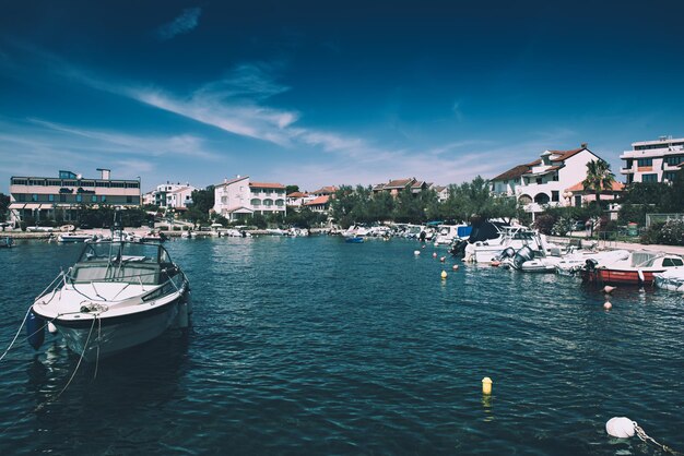 Coastal village of Petrcane in Dalmatia, Croatia with blue sea water and yachts, travel destination touristic background