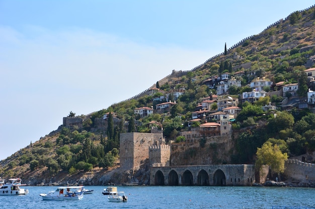 coastline with ancient fortress and houses among green trees, Turkey