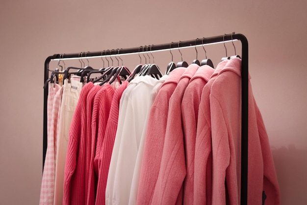 Coat and sweater blouses in pink on a hanger in a store Classic women's fashion clothes