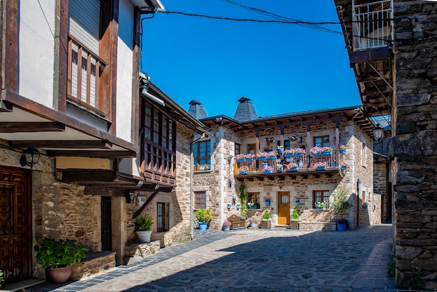 Cobblestone street with picturesque stone residential buildings and flowered balconies in Puebla de Sanabria sPAIN