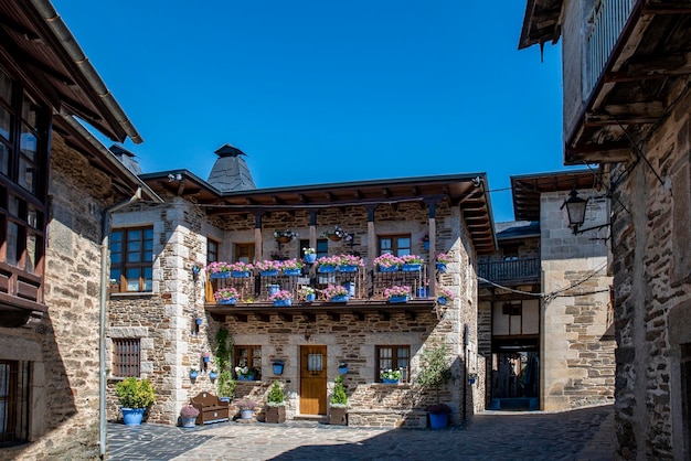 Cobblestone street with picturesque stone residential buildings and flowered balconies in Puebla de Sanabria sPAIN