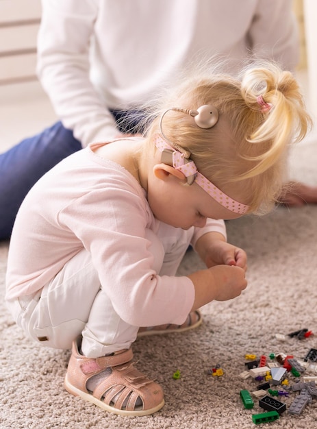 Cochlear implant for baby Deaf child with hearing aid plays in living room